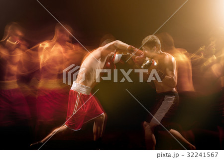 The two male boxers boxing in a dark studio The two male boxers boxing in a dark studio 32241567