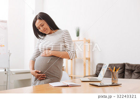 Delighted caring mother expecting a baby Delighted caring mother expecting a baby 32243321