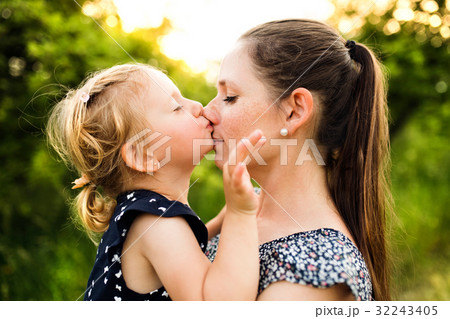 Young mother in nature holding little daughter in 32243405