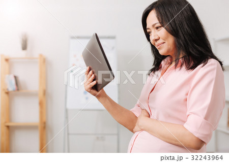 Pleasant pregnant woman using tablet 32243964