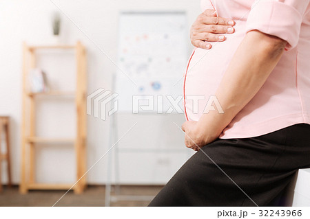 Caring pregnant mother touching her belly Caring pregnant mother touching her belly 32243966