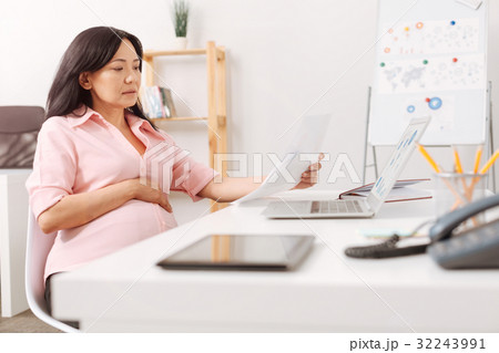 Serious pregnant woman working in the office Serious pregnant woman working in the office 32243991