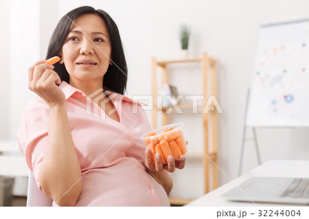 Nice pregnant woman eating baby carrot 32244004