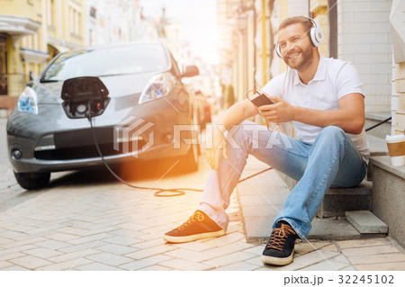 Upbeat man listening to the music on the steps 32245102