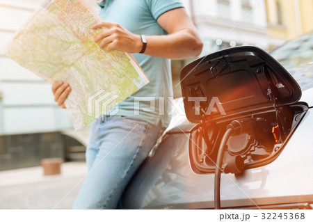 Young man planning itinerary while car being Young man planning itinerary while car being 32245368