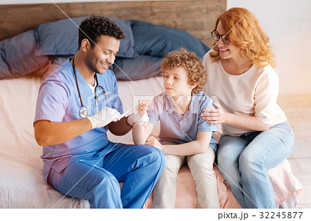 Positive delighted doctor treating his patient Positive delighted doctor treating his patient 32245877