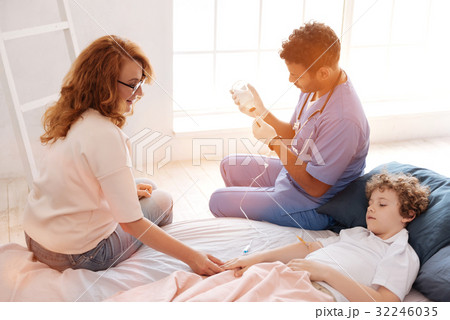 Sad ill boy looking at hand of his mother 32246035