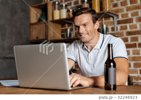 Cheerful nice guy enjoying his work from home Cheerful nice guy enjoying his work from home 32246923