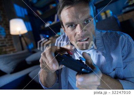 Expressive young guy being emotional while playing 32247010