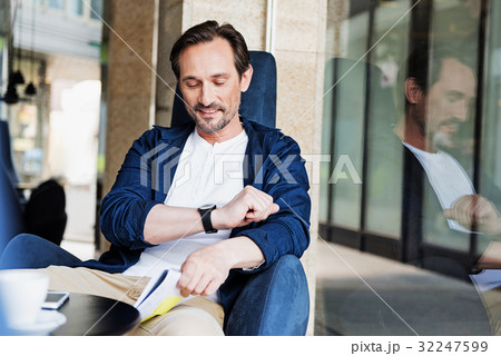 Joyful man checking time on wristwatch 32247599