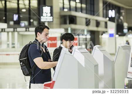 自動チェックイン機を使う外国人バックパッカー 32250335