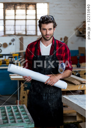 Carpenter with plans smiling Carpenter with plans smiling 32253640