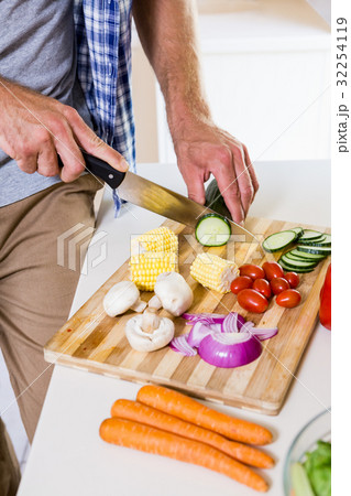 Mid-section of man chopping vegetable in kitchen 32254119