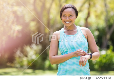 Happy woman posing and touching her watch 32254418