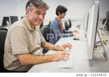 Portrait of happy professor working on computer 32254670