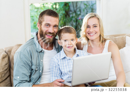 Portrait of parents and son using laptop in living room Portrait of parents and son using laptop in living room 32255038