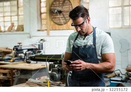 Carpenter using phone Carpenter using phone 32255172