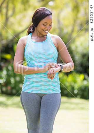Happy woman looking her watch Happy woman looking her watch 32255447