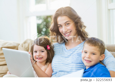 Mother sitting with her kids on sofa Mother sitting with her kids on sofa 32255693
