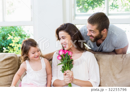 Mother receiving a bunch of flowers from her daughter 32255796