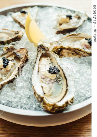 Raw and fresh Oyster with caviar on top and lemon Raw and fresh Oyster with caviar on top and lemon 32256068
