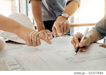 Architects engineer discussing at the table with blueprint - Clo 32257684