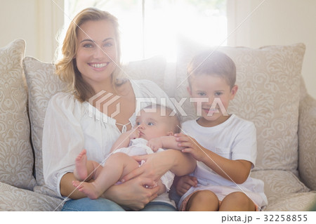Portrait of mother sitting on sofa with her kids Portrait of mother sitting on sofa with her kids 32258855