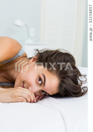Portrait of beautiful woman lying on bed 32258857