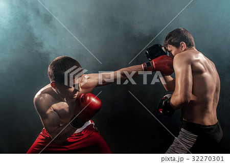 Two professional boxer boxing on black smoky Two professional boxer boxing on black smoky 32270301