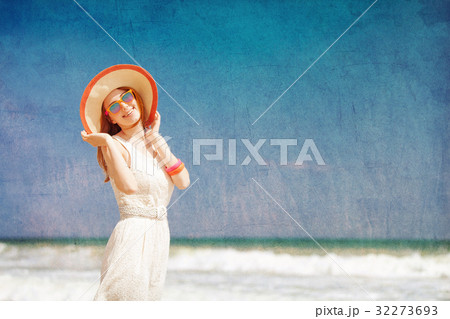 Young woman in hat and sunglasses at sea 32273693