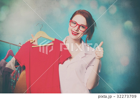 young woman with shirt on hanger near clothes young woman with shirt on hanger near clothes 32273709