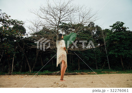 Beautiful young woman in tunic on beach with large 32276061