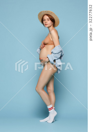 Young beautiful pregnant woman standing on blue Young beautiful pregnant woman standing on blue 32277632