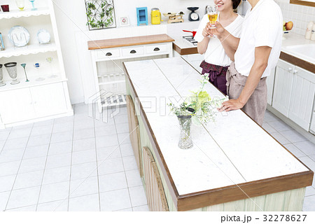 キッチンでグラスを傾けるカップルのイメージカット キッチンでグラスを傾けるカップルのイメージカット 32278627