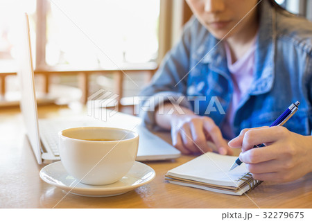 woman's hand using laptop and writing in notepad woman's hand using laptop and writing in notepad 32279675