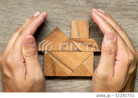 Hands hold the tangram puzzle in home shape Hands hold the tangram puzzle in home shape 32281731