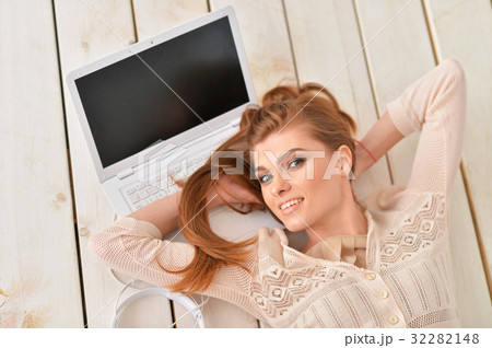young woman lying on floor with laptop 32282148