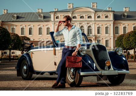 Confident wealthy young man with briefcase near Confident wealthy young man with briefcase near 32283769
