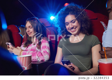 Young woman using smart phone at the cinema 32284353