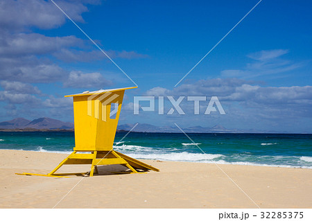Yellow lifeguard tower. One life guard together 32285375