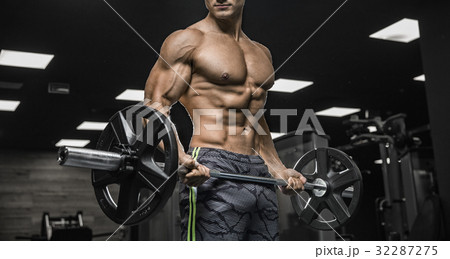 Handsome man with big muscles, posing at the camera in the gym 32287275