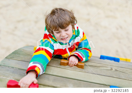 Happy blond kid boy having fun and climbing on 32292185