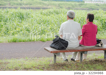 ベンチに座るシニア夫婦 後ろ姿の写真素材