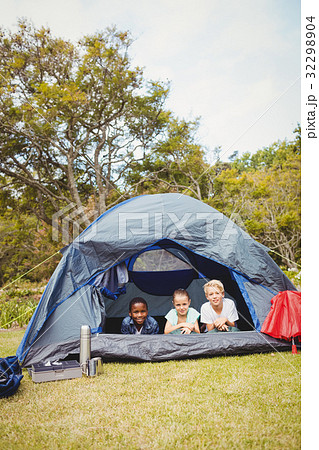 Children lying and smiling on a tent 32298904