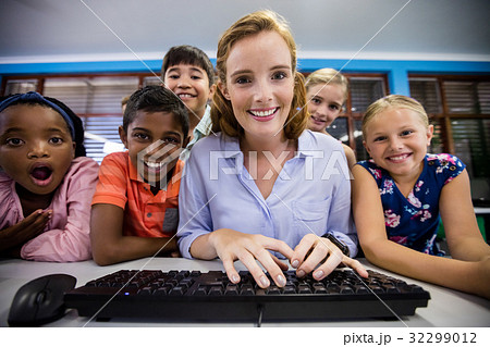 Teacher giving lesson to her students with technology 32299012