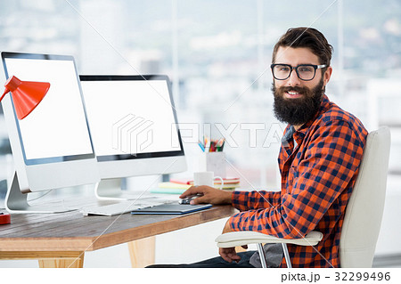 Hipster sitting in front of a computer 32299496