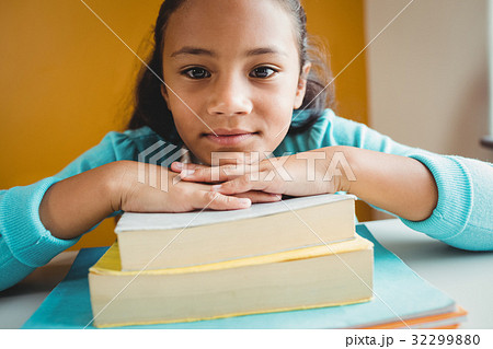 Girl leaning her head on pile of books 32299880