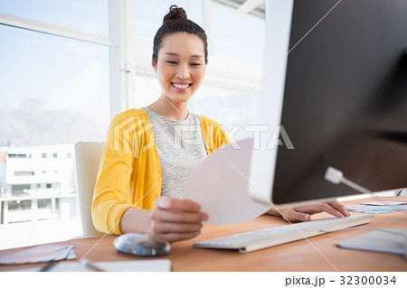 A businesswoman is working at her desk 32300034