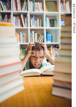 Upset boy sitting at a desk Upset boy sitting at a desk 32300188