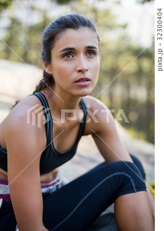 Portrait of woman looking up with climbing equipment Portrait of woman looking up with climbing equipment 32300404